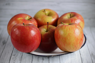Fresh red apples on white wooden background