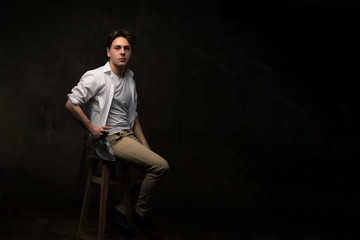 Handsome young man on black background looking at camera.