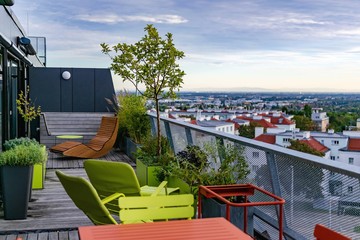 View from a rooftop terrace over southern Vienna with rooftop garden and chill-out area