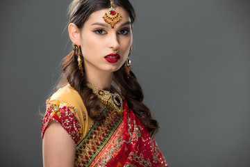 Fototapeta premium beautiful indian woman in sari and accessories, isolated on grey