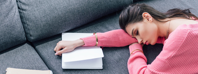 tired indian student sleeping on sofa with notebook and book