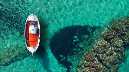 Aerial drone top view photo of beautiful traditional fishing boat docked in clear waters of Koufonisi island port, Cyclades, Greece