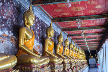 Beautiful golden Buddha images at corridor in Wat Suthat temple, Thailand. Wat Suthat Thepphawararam is a royal temple of the first grade in Bangkok. Construction of the temple was completed in 1847.