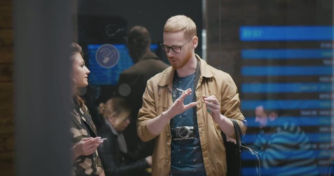 Cute young couple travelers smoke at the airport