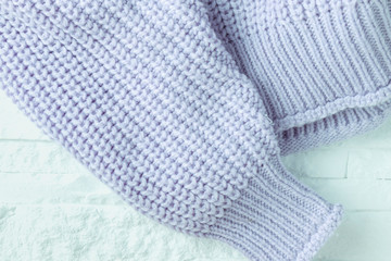 knitted jacket blue on white brick background