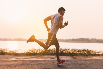 Fototapeta premium young man runner running on running road in city park