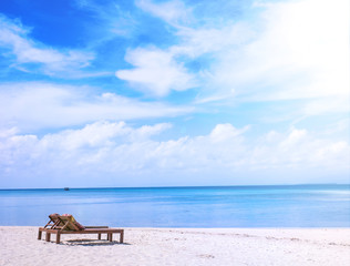 Chairs on the amazing beautiful sandy beach near the ocean with blue sky. Concept of summer leisure calm vacation for a tourism idea. Empty copy space, inspiration of tropical landscape