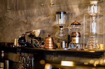 Coffee equipment and drinks placed on the shelves, including a glass jar, kettle, available at the store