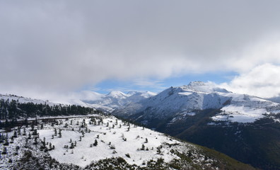 Fototapeta na wymiar Winter landscape with snowy mountains and cloudy grey sky. Ancares Region, Lugo Province, Spain.
