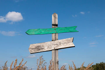 old wooden signpost with two arrows with copy space