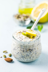 Lemon poppy seed overnight oats with honey on light blue background. Selective focus, space for text.