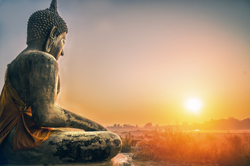 sitting Budha statue facing sunrising