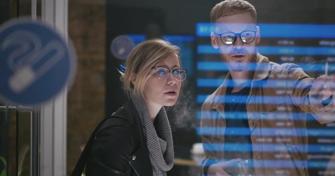 Young couple - girl smoking an electronic vape and a man with a cigarette