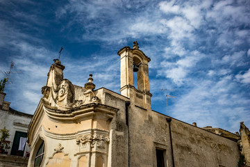 Fototapeta premium The amazing medieval Church of Madonna dei Martiri in the stunning town of Altamura in the Puglia region, South Italy. Close-up street detail view. Lovely sunny summer day with puffy white clouds