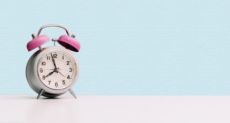 Retro styled white alarm clock, isolated and copy space, pink blue