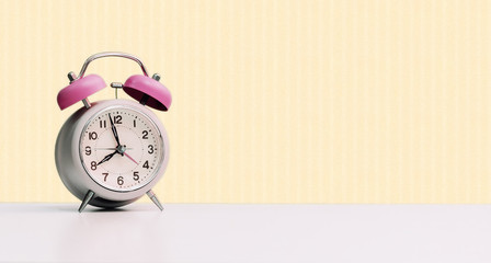Retro styled white alarm clock, isolated and copy space, pink yellow