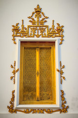Beautiful golden window with white cement background in Thai temple.