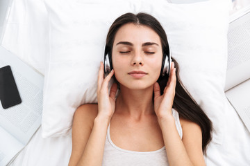 Top view of a beautiful young woman listening to music