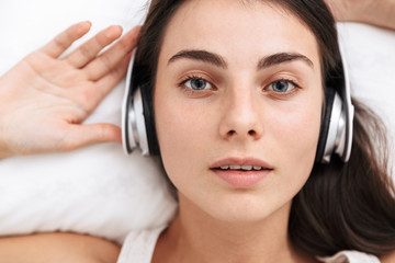 Top view of a beautiful young woman listening to music