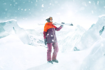 Fototapeta na wymiar Female skier standing with skies in one hand on beautiful mountain landscape background. Winter, ski, snow, vacation, sport, leisure, lifestyle concept