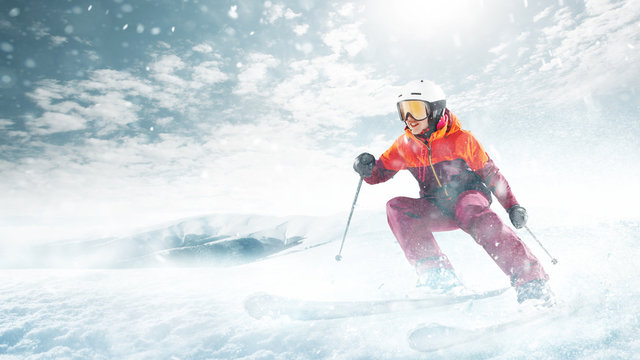 Young Beautiful Athlete Woman Doing Winter Sport - She Is Skiing Against White Alps Mountain Background