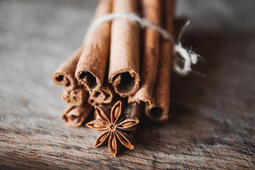 Cinnamon sticks and aniseon on the wooden surface.