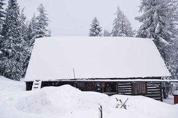 Couple standing on the porch of a snow covered chalet 