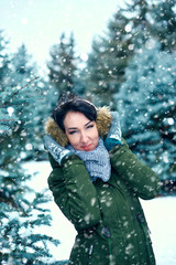 Fototapeta na wymiar beautiful woman is in winter forest, green fir trees with snow