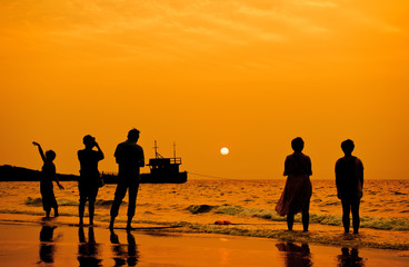 Fototapeta na wymiar Silhouette the tourist at sunrise on the beach.