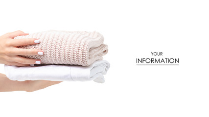 Stack of clothing white jeans and beige sweater in hand pattern on a white background isolation