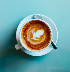 Abstract coffee background, saucer, spoon, white cup, close up. Top view.