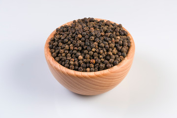 Fototapeta na wymiar Black pepper peppercorns in wooden bowl isolated on white background. Closeup.