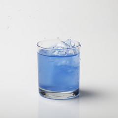 Storm in a glass of water. Frozen splashes of water in a glass of blue liquid.