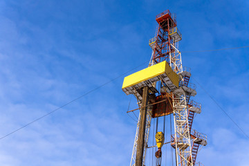 Oil and Gas Drilling Rig onshore dessert with dramatic cloudscape. Oil drilling rig operation on the oil platform in oil and gas industry. Land drilling rig blue sky
