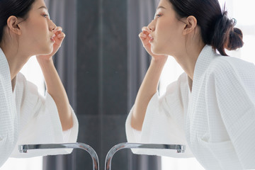 Fototapeta premium beautiful asian woman bare skin in white bathrobe wash and clean facial with care in morning freshness sunlight