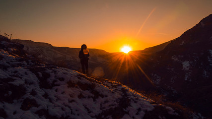 una persona in montagna guarda tramonto