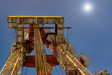 Oil and Gas Drilling Rig onshore dessert with dramatic cloudscape. Oil drilling rig operation on the oil platform in oil and gas industry. Land drilling rig blue sky