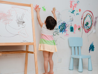 A little girl, 3 years old, painted an arched look with paint and a brush on the wall of her room....