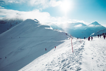 People enjoying beautiful weather in snow covered mountains