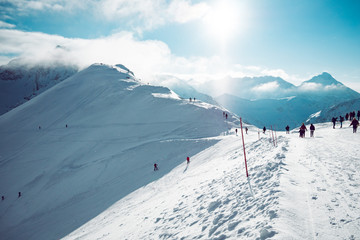 Fototapeta premium People enjoying beautiful weather in snow covered mountains