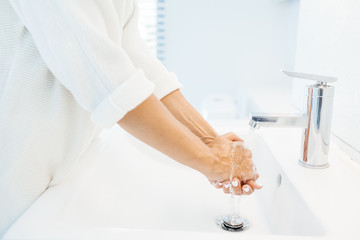 Woman washing hands in washroom