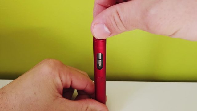 Close-up - man fill the electronic cigarette with liquid