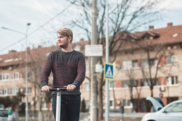 millennial guy riding electric scooter for outdoor personal transportation ecologic alternative e-scooter, personal electric vehicle kickscooter future urban transport technology for smart city