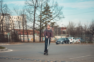 Fashion guy riding electric vehicle for outdoor personal transportation ecologic alternative e-scooter, personal electric vehicle kickscooter, segway future urban transport technology for smart city