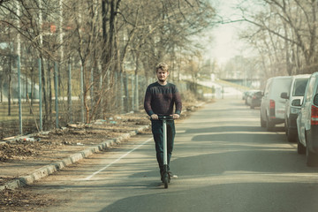 Guy using electric vehicle for outdoor personal transportation ecologic alternative e-scooter, personal electric vehicle kickscooter
