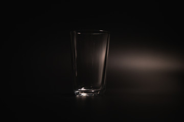 Water is poured into a transparent glass on a dark background