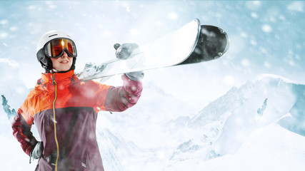 Female skier standing with skies in one hand on background of beautiful mountain landscape. Winter,...