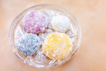 Four round whole mochi glutinous rice cake dessert pieces colorful multicolored natural food dye wagashi daifuku filled with ice cream