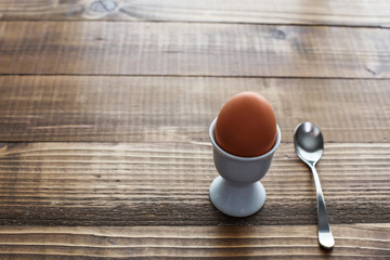 Boiled egg on wooden table with spoon
