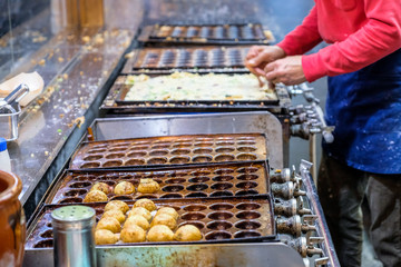 Takoyaki ball process to cooking by hand , takoyaki (octopus dumplings) famous Japanese snack food , Takoyaki traditional food Osaka in Japan